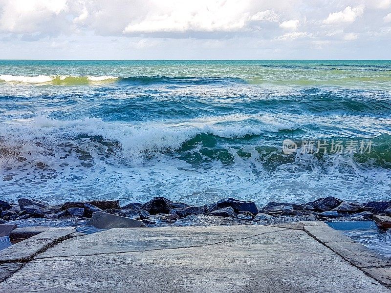 在巴西累西腓的Boa Viagem海滩，强大的蓝色海浪正向海浪块前进